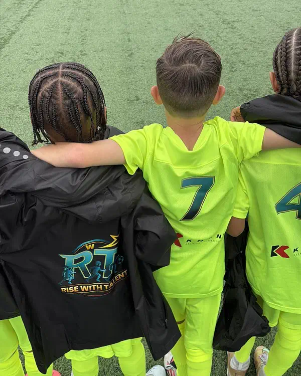 Spelers van Rise With Talent met de armen om elkaar heen op het veld